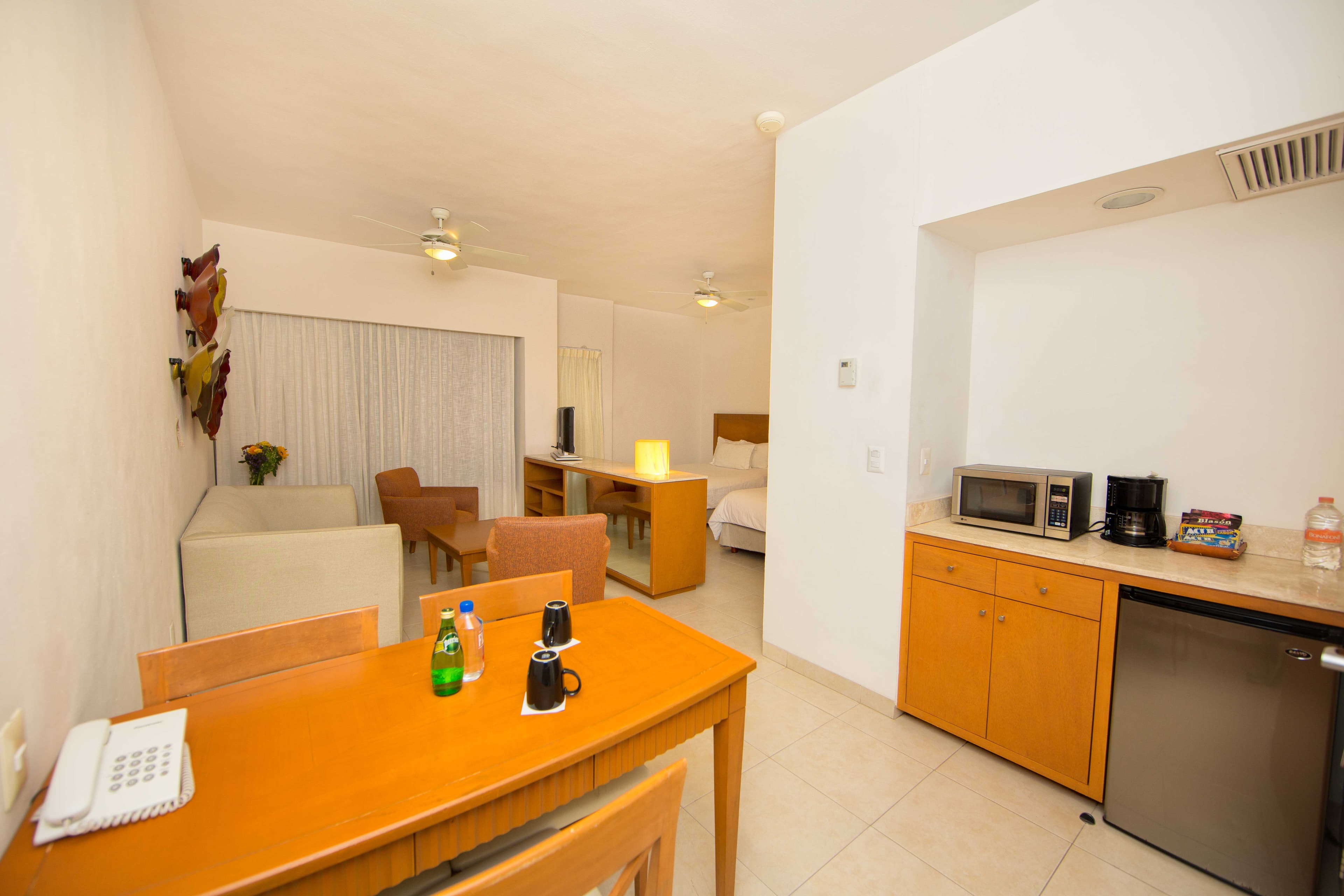 Jr Suite interior with dining area, kitchenette and bedroom at Ambiance Suites