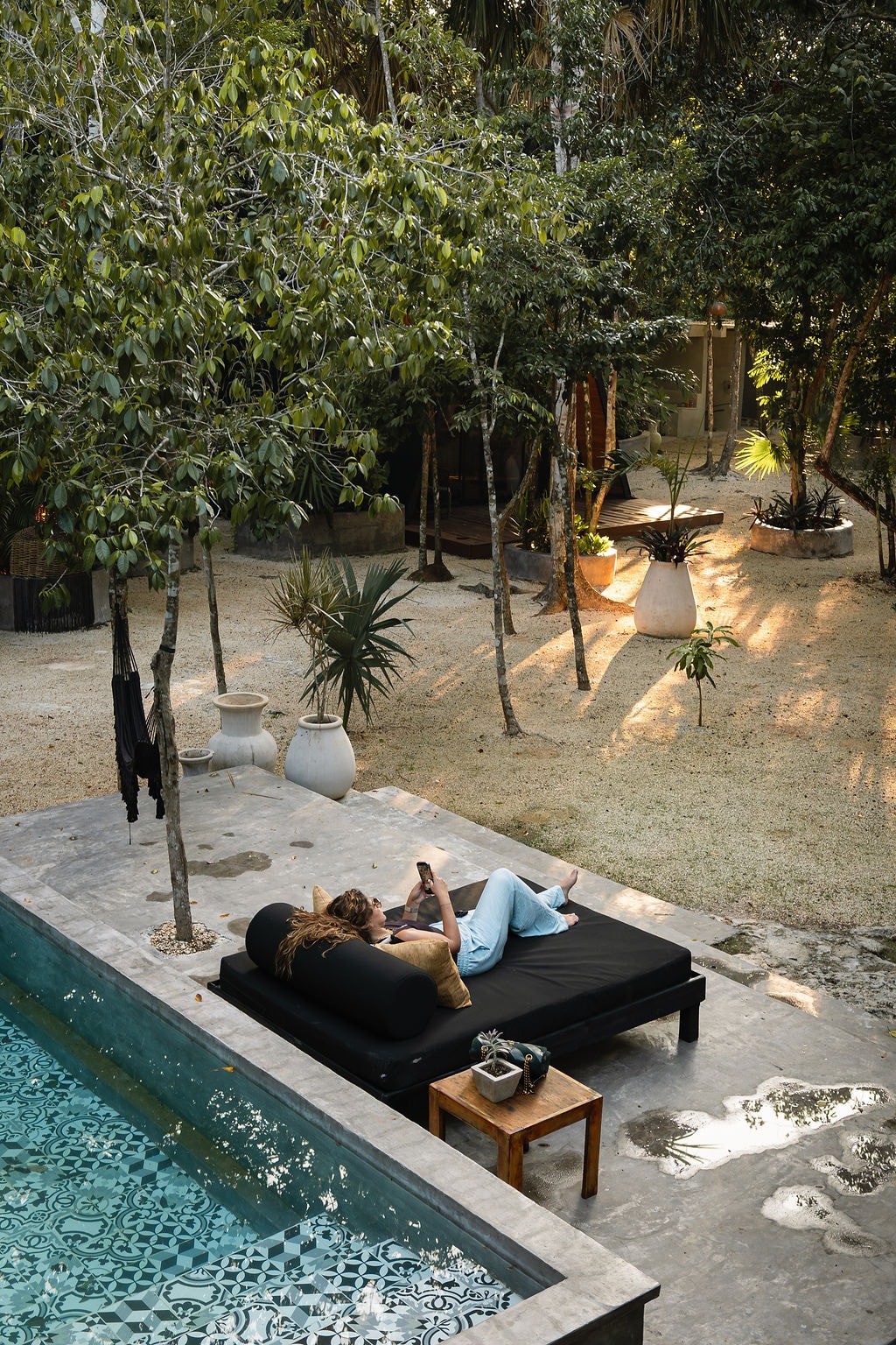 Guest relaxing on a sun lounger beside the pool at Casa Tattva
